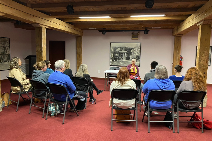 People meditating in chairs with an instructor